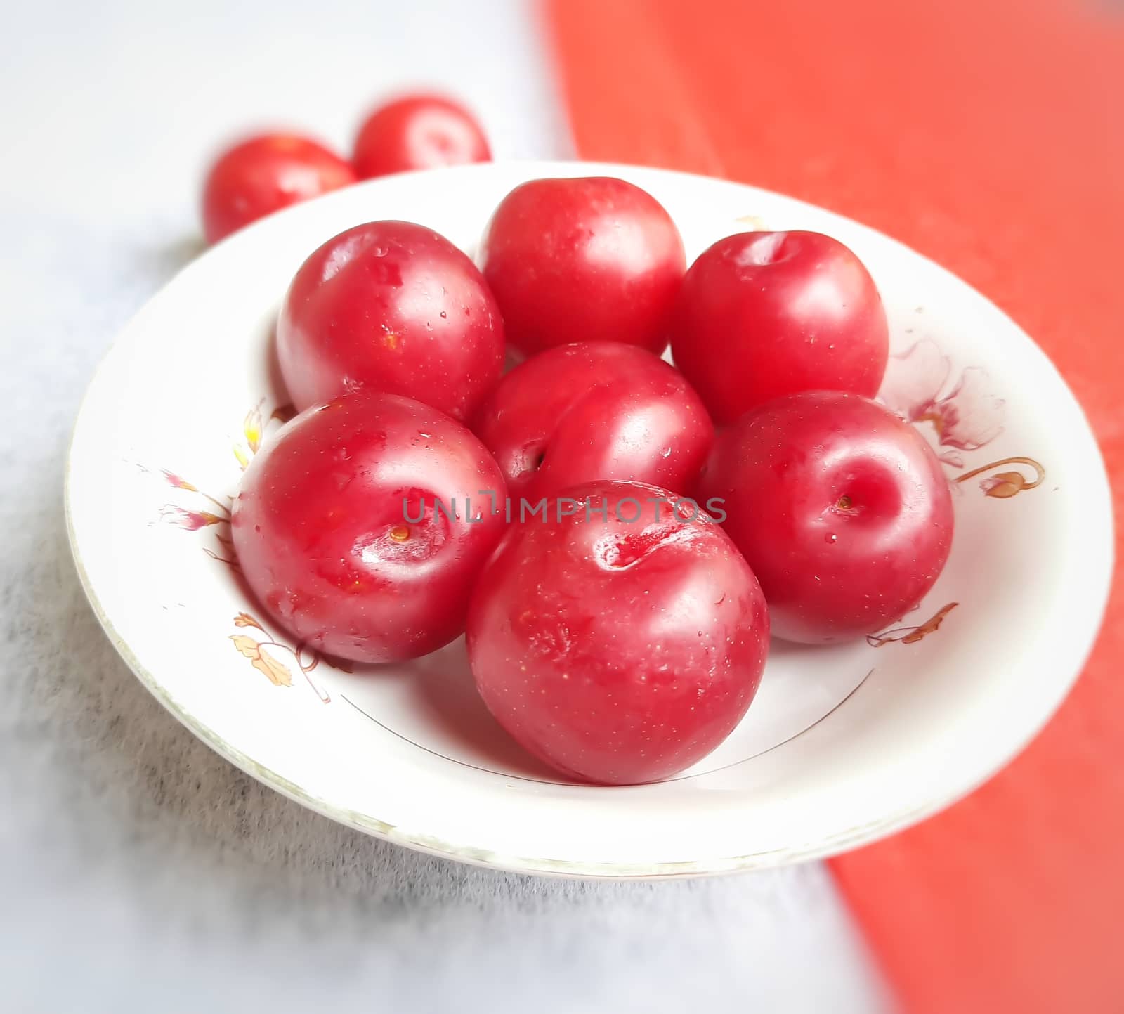 Colorful Red plums kept in bowl placed in red and white backgrounds and reduce the risk of cancer heart disease and diabetes