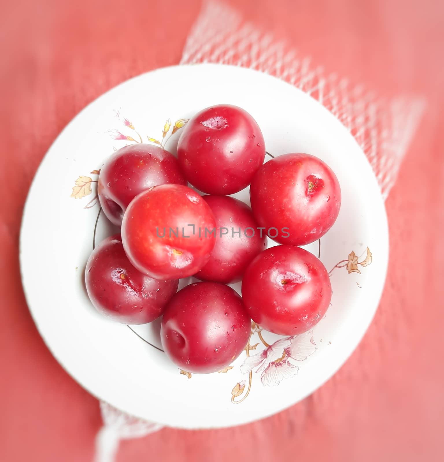 Colorful Red plums kept in bowl placed in red backgrounds and reduce the risk of cancer heart disease and diabetes