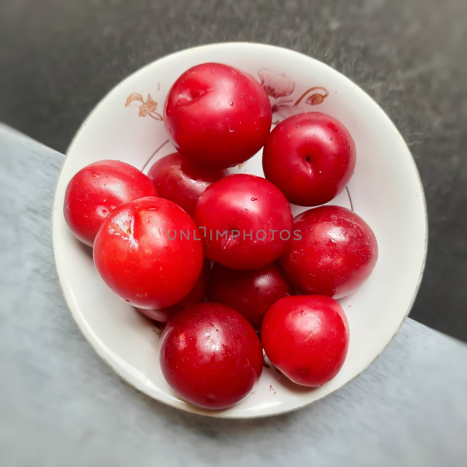 Colorful Red plums kept in bowl placed in black and white backgrounds and reduce the risk of cancer heart disease and diabetes by AnithaVikram