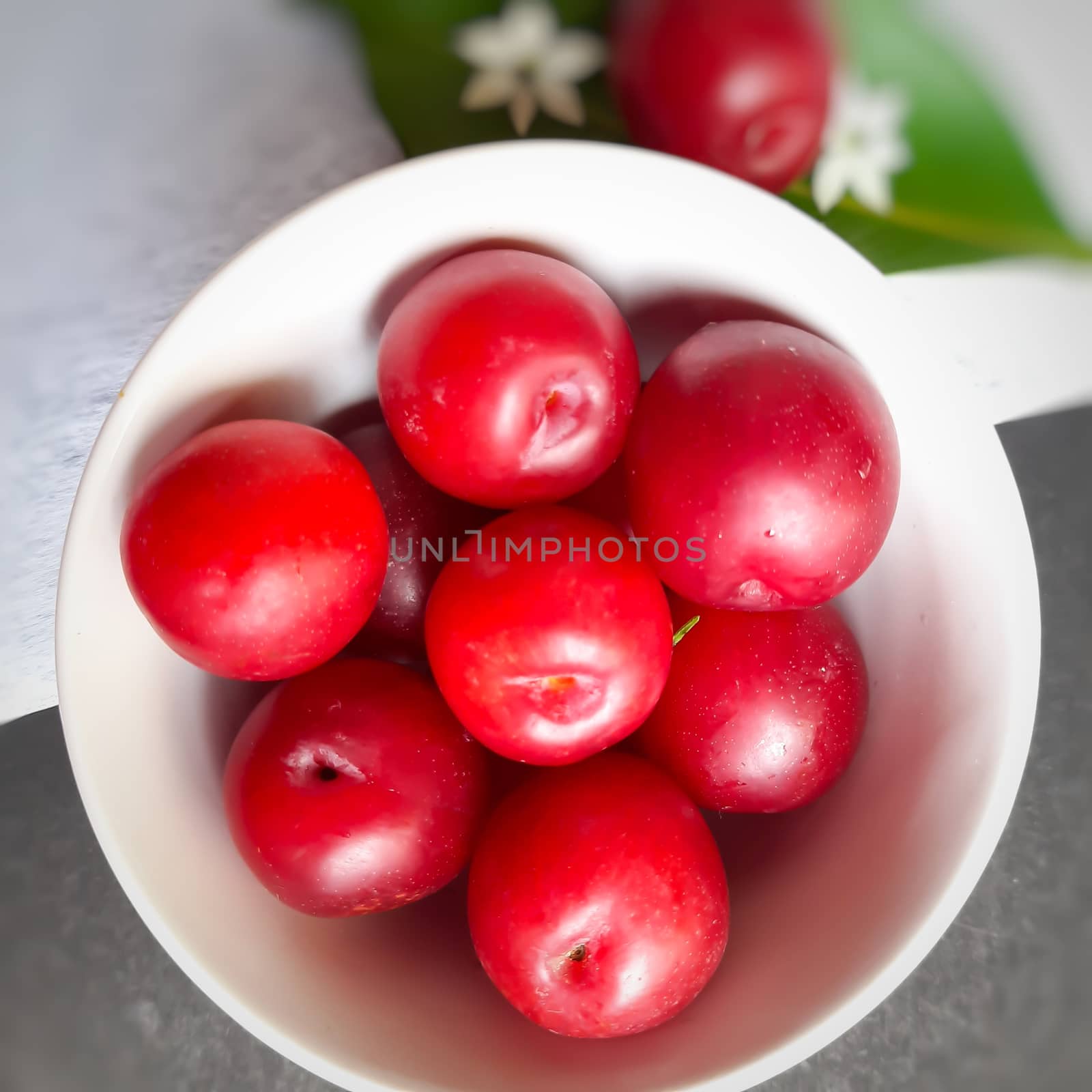 Colorful Red plums kept in bowl placed in black and white backgrounds and reduce the risk of cancer heart disease and diabetes by AnithaVikram