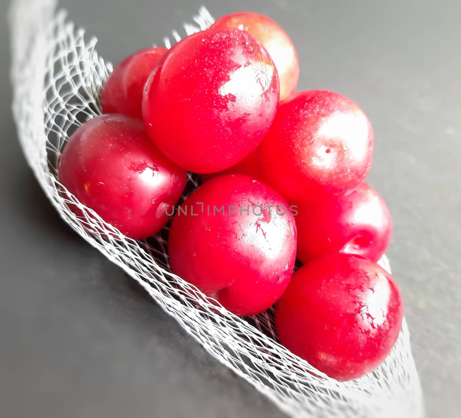 Colorful Red plums kept in fruit cover placed in black background and reduce the risk of cancer heart disease and diabetes