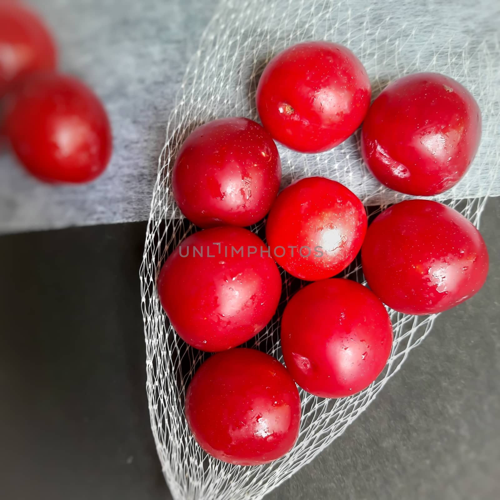 Colorful Red plums kept in fruit cover placed in black background and reduce the risk of cancer heart disease and diabetes by AnithaVikram