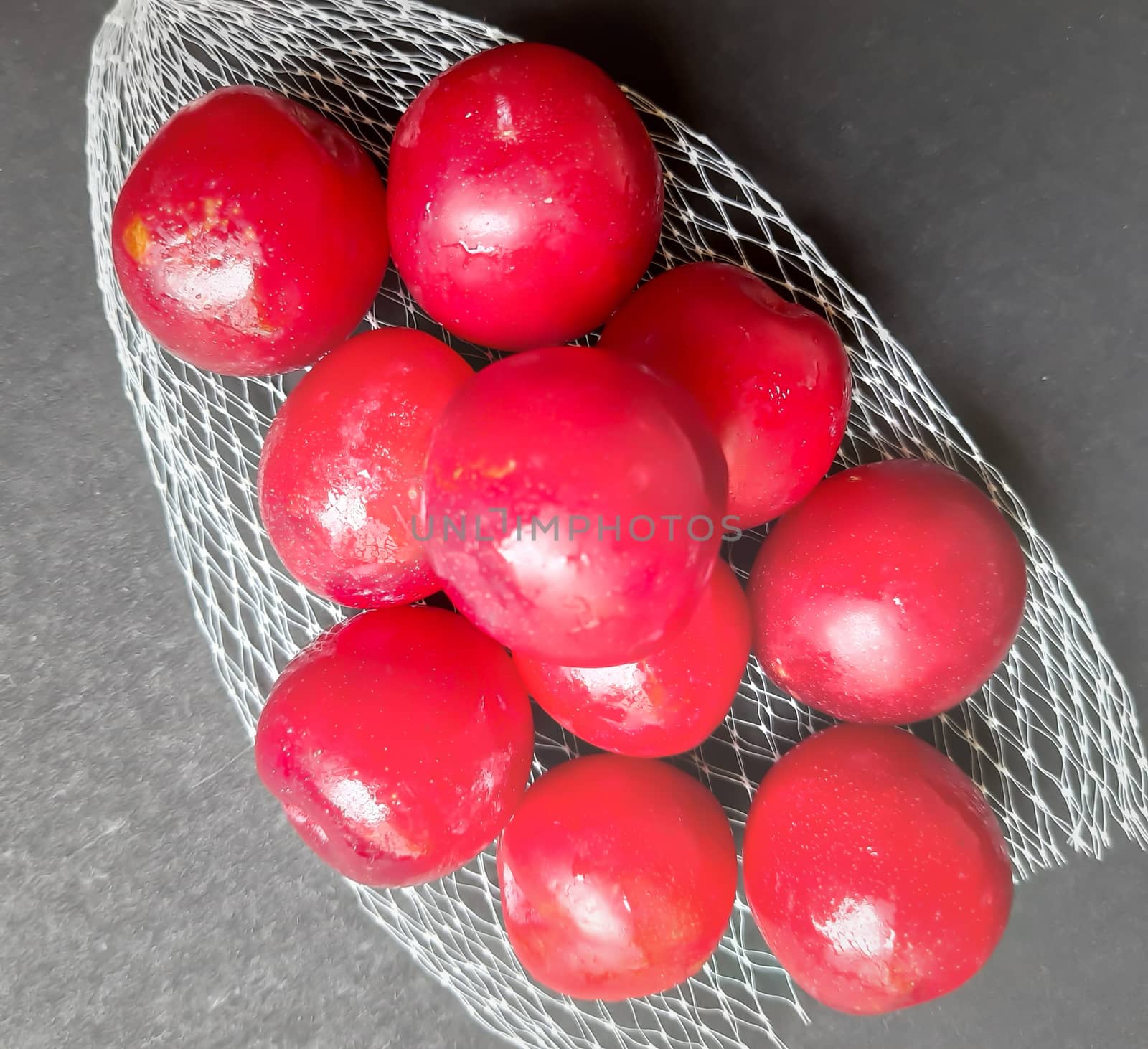 Colorful Red plums kept in fruit cover placed in black background and reduce the risk of cancer heart disease and diabetes