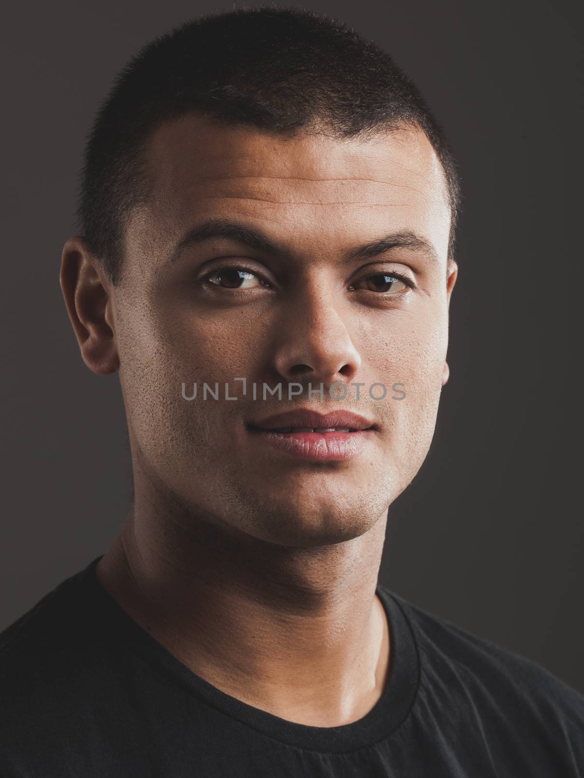Portrait of a young male latino model over a gray background