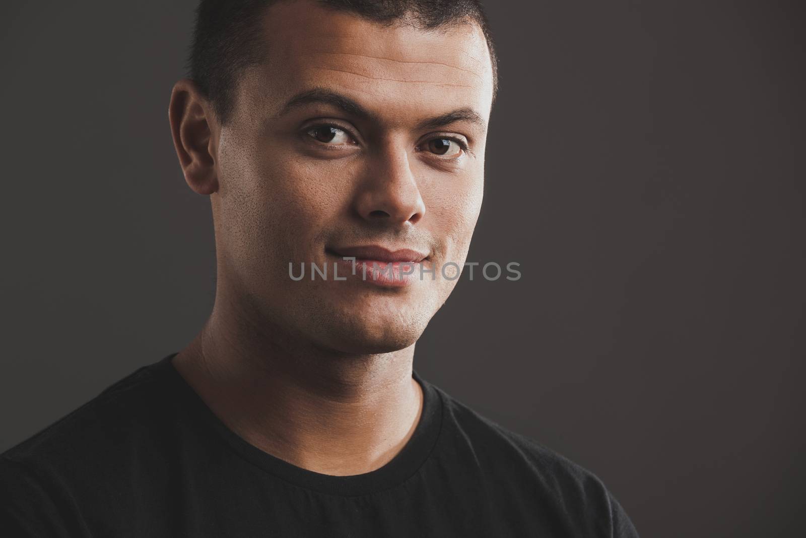 Portrait of male latino model over a gray background