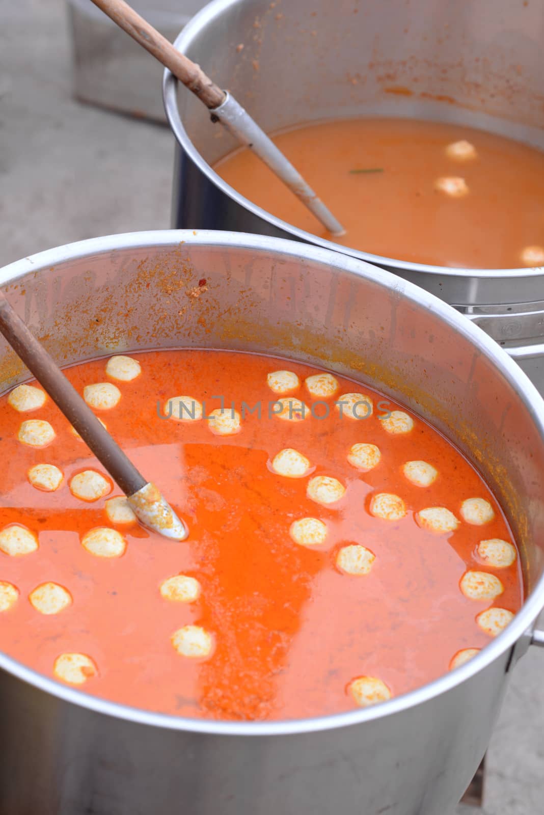 Fish Curry Sauce with fish balls in a large pot  on a blurred background.
