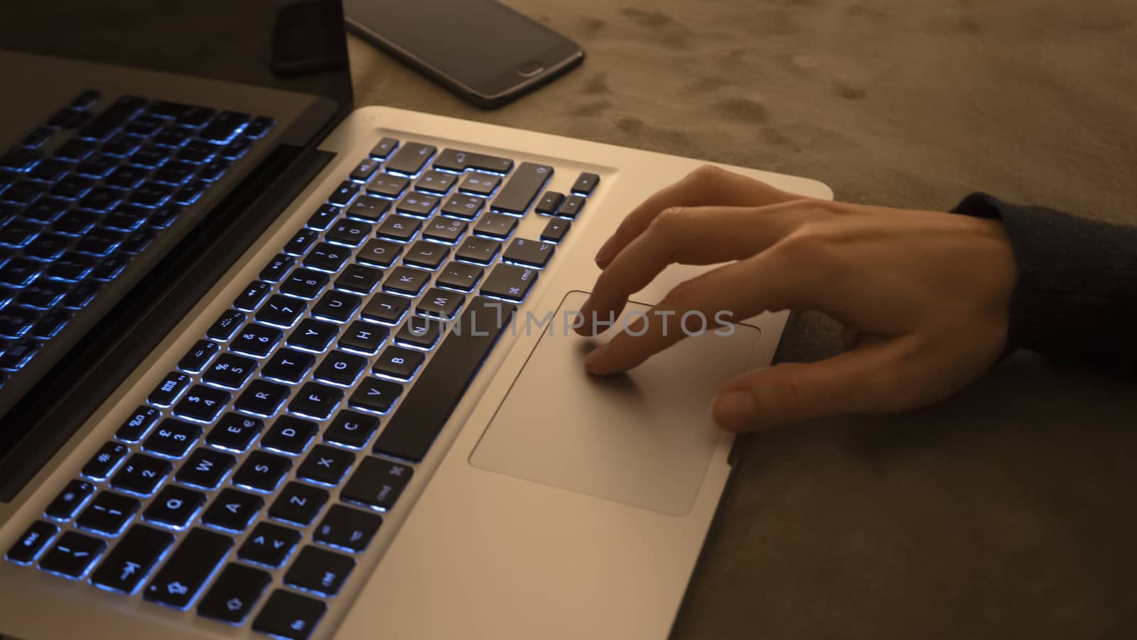 Couple relationships and dating in modern times concept: closeup of woman's hands typing on laptop keyboard in low light ambient