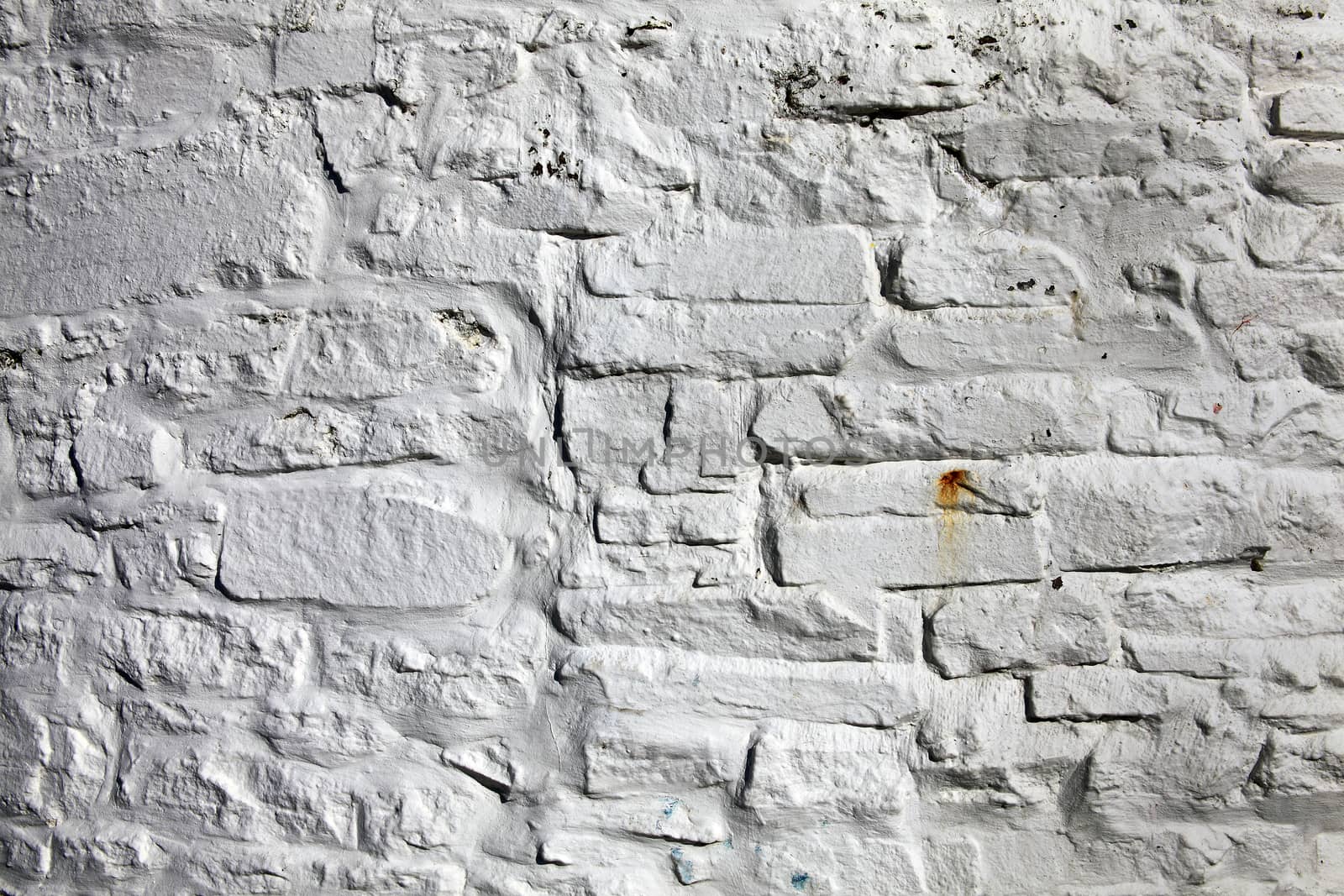 Old fashioned dirty grey painted brick stone wall background by ant