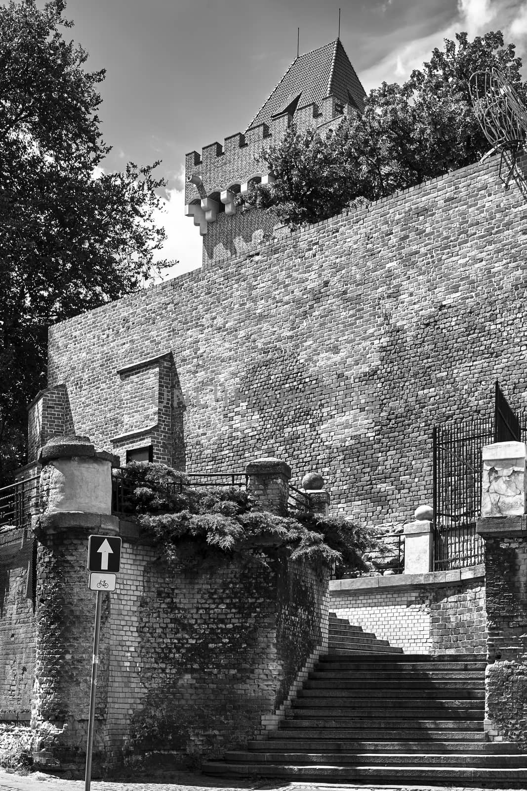 Medieval defensive wall and stone stairs at the royal castle in Poznan, black and white