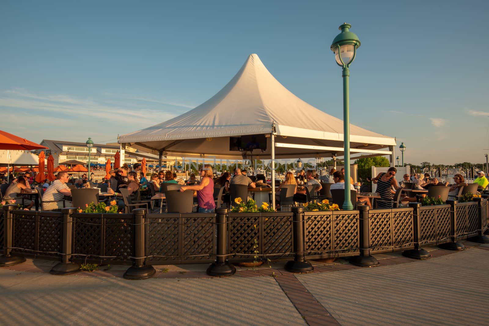 Belmar, NJ, USA -- July 19, 2017. A wide angle photo of people enjoying outdoor cocktails and dining on the waterfront at the Belmar Marina.