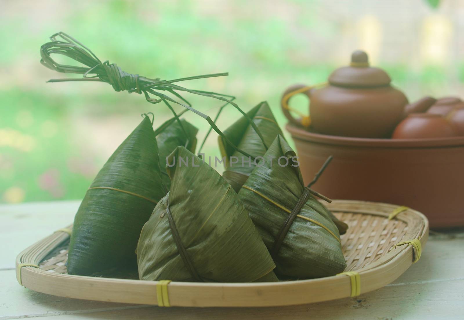 Chinese tradition food - Chinese Steamed Rice Dumpling  with green background outdoor.Zongzi or traditional chinese sticky rice dumpling usually taken during festival occasion. 