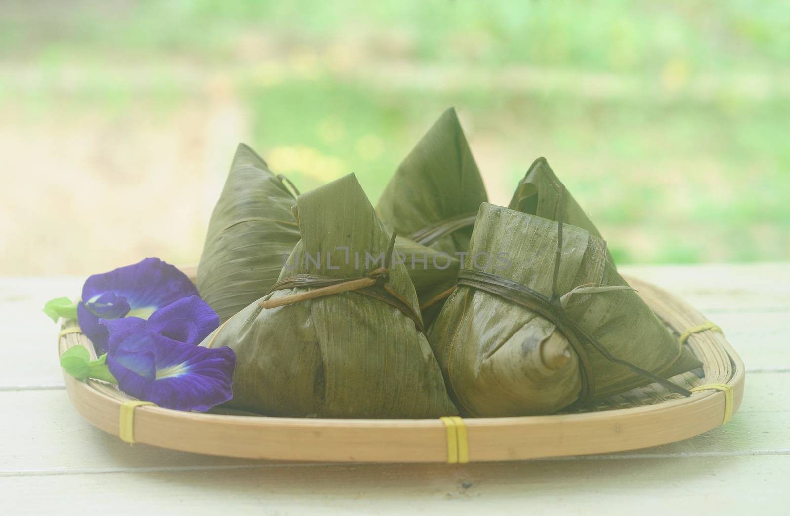 Chinese tradition food - Chinese Steamed Rice Dumpling  with blur background outdoor.Zongzi or traditional chinese sticky rice dumpling usually taken during festival occasion. 