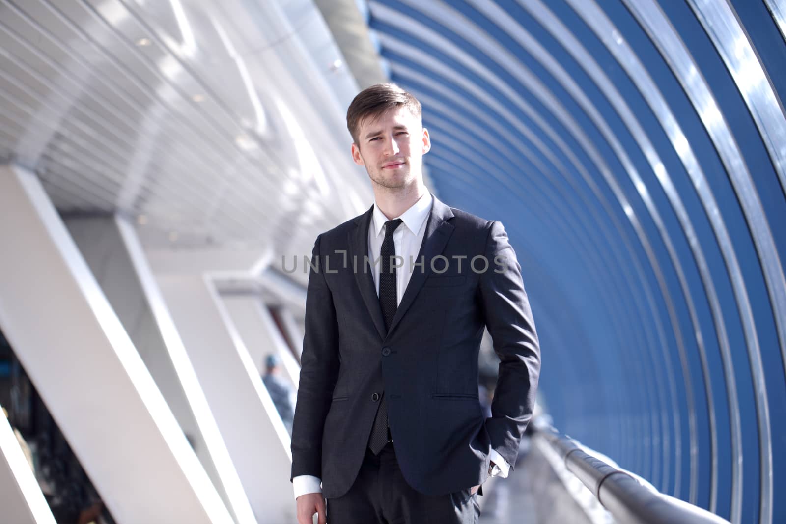 Portrait of a young businessman in suit standing at office