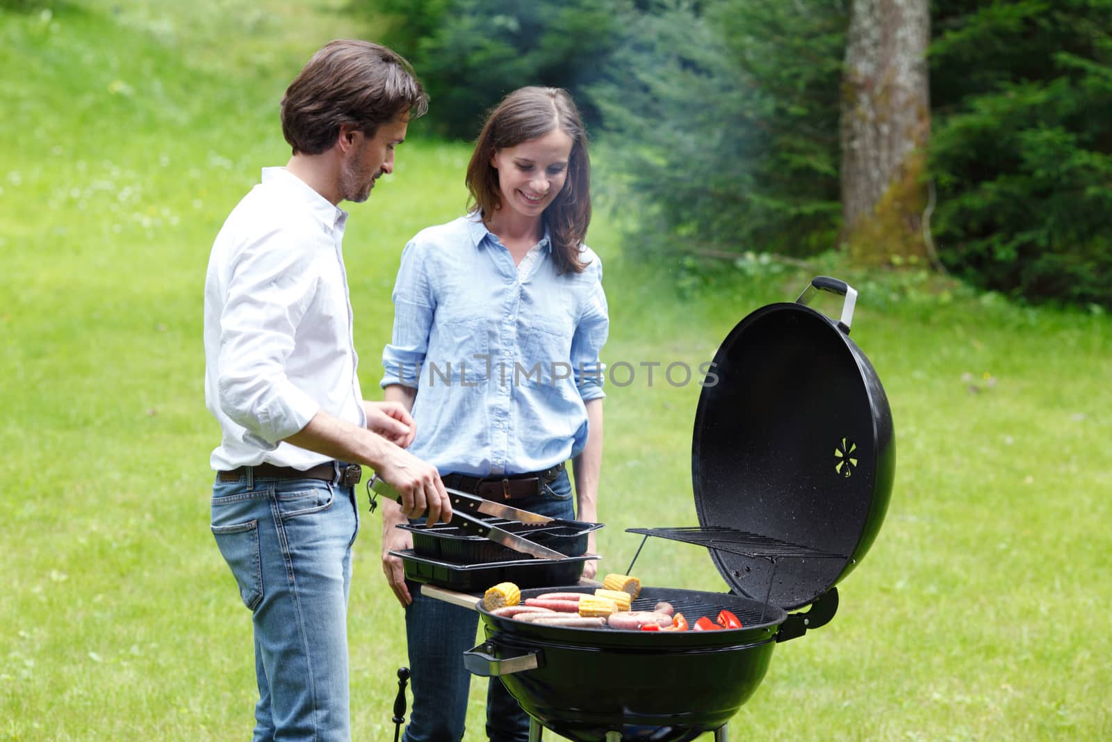 Couple cooking food on barbecue by ALotOfPeople