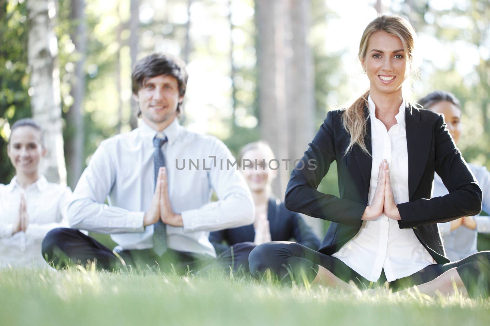 Business people team practicing yoga in park