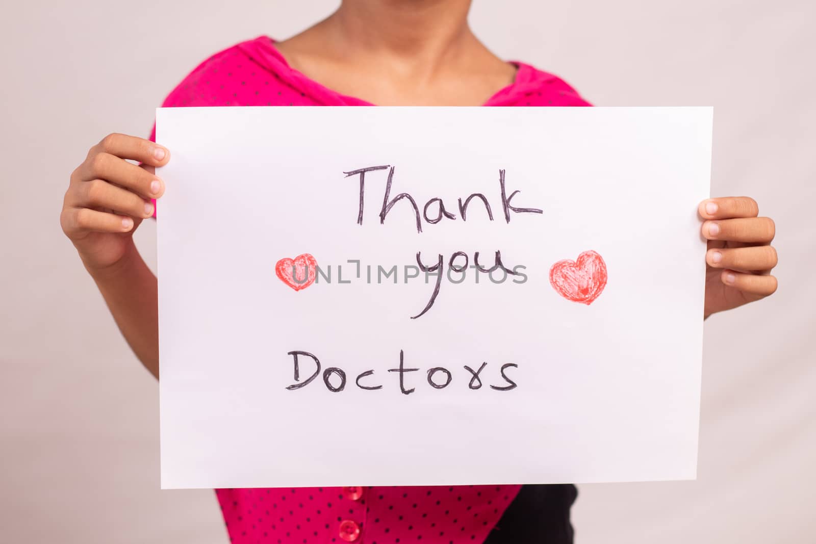 Kid Holding thankful greetings to the doctors and medical frontliners signage, who working during coronavirus or covid-19 pandemic.