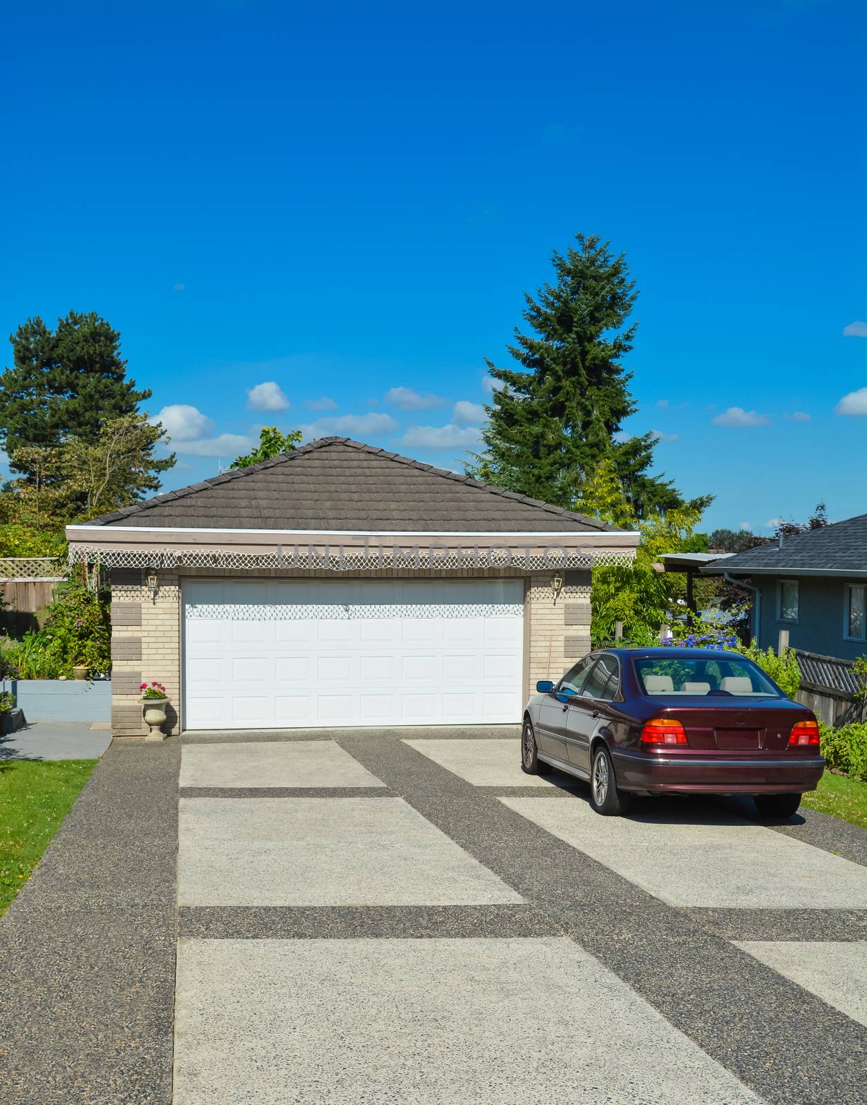 Passenger car parked on bar colored concrete driveway at the garage