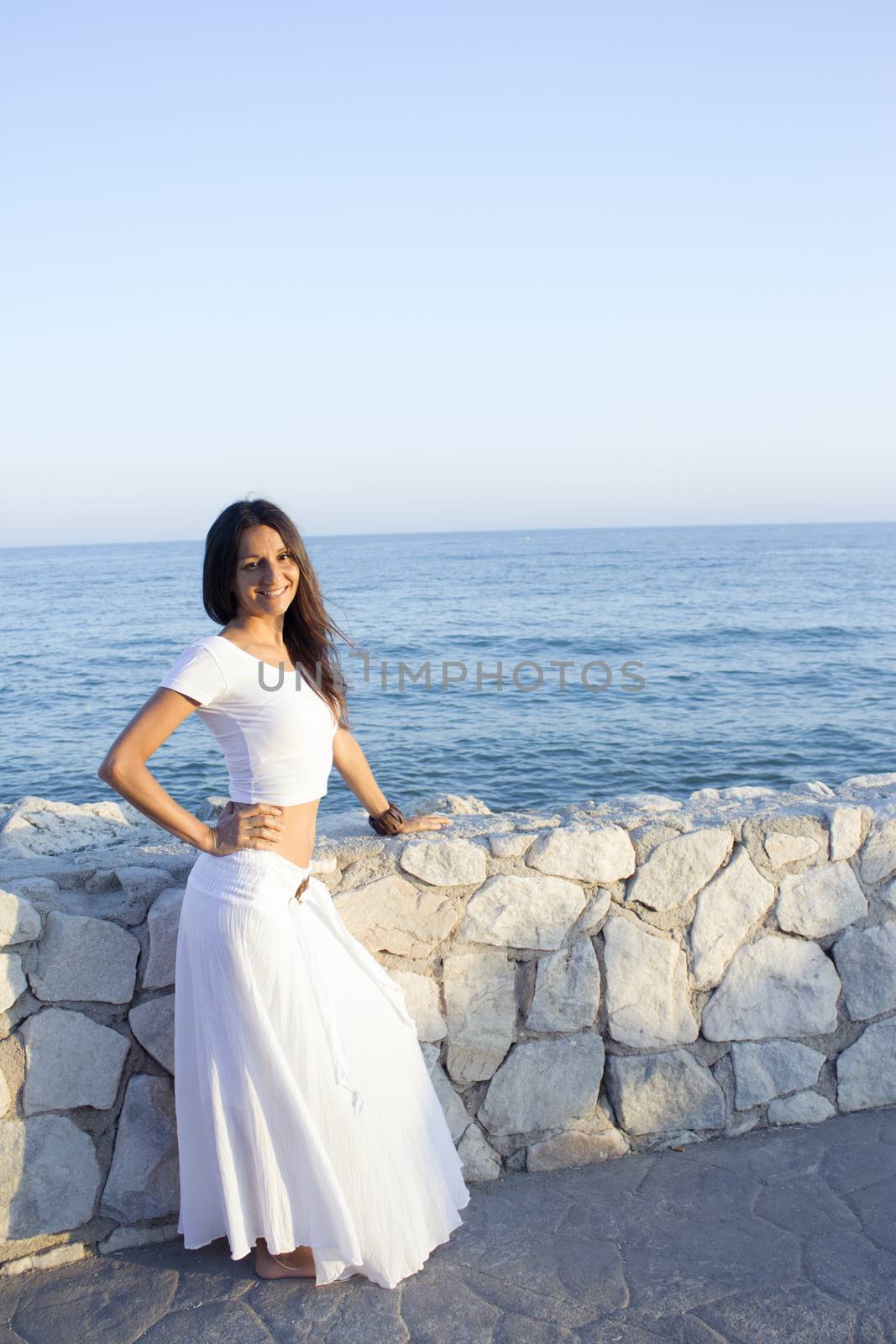 Woman in white dress on the beach with happy expression