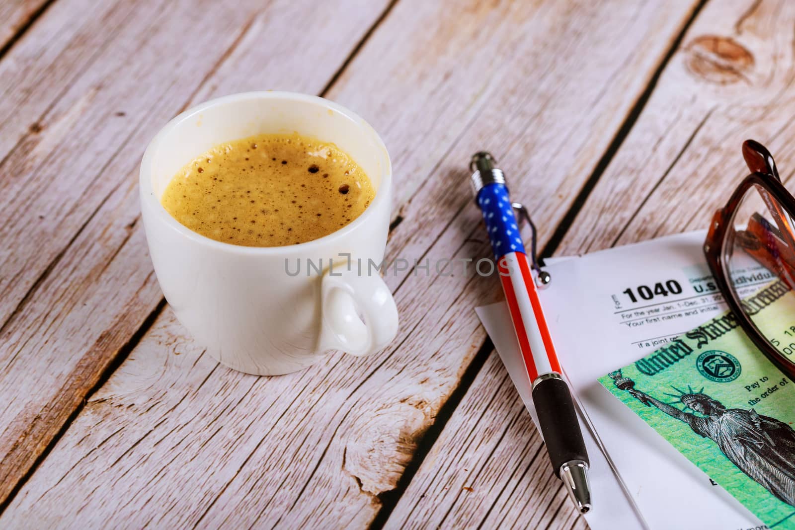 Tax season an office with a glasses and pen on income tax return 1040 form with black coffee by ungvar