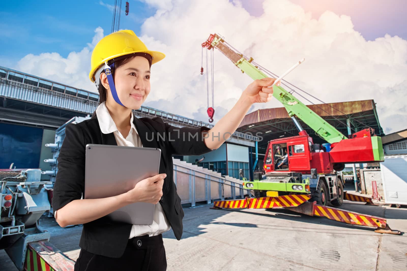 Young woman engineer holding digital tablet wtih smile in constr by Surasak