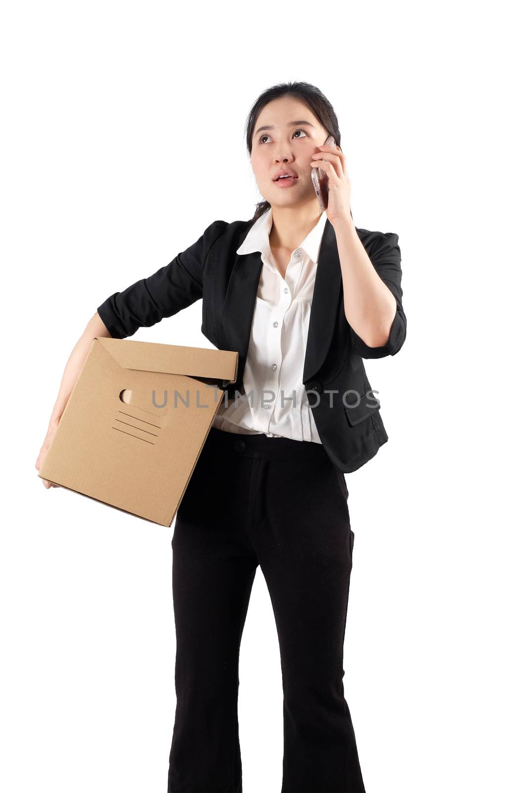 A young woman carrying a box and talking on the phone