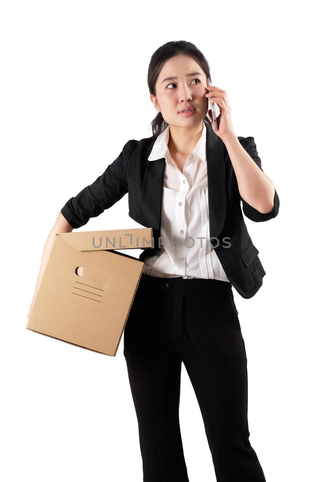 A young woman carrying a box and talking on the phone