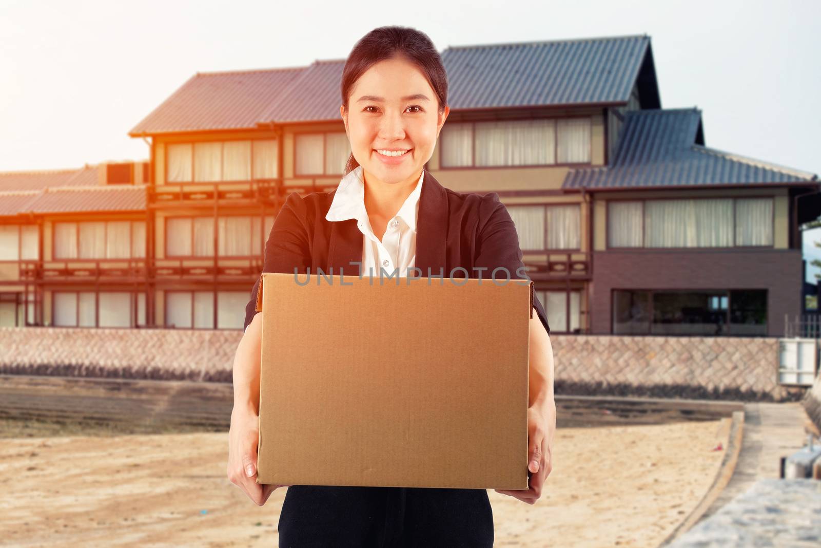 A young woman carrying a box on japanese house background