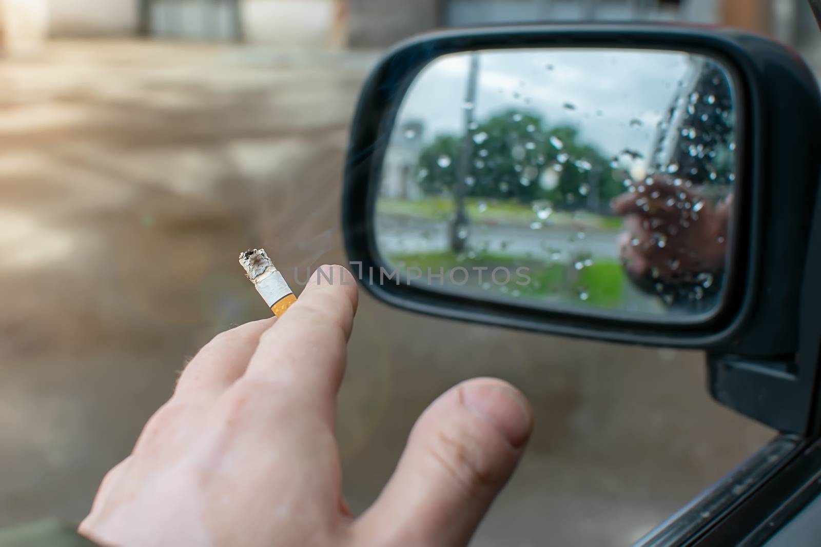 car driver hand with a cigarette