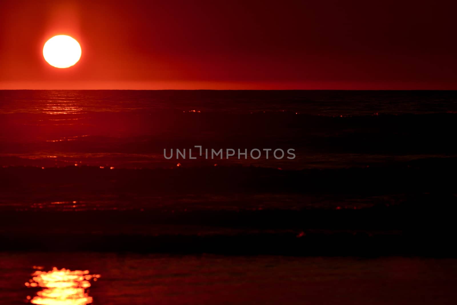 Dramatic sunset colours; beautiful sunset on a beach. Sun reflection in the water. by Marshalkina