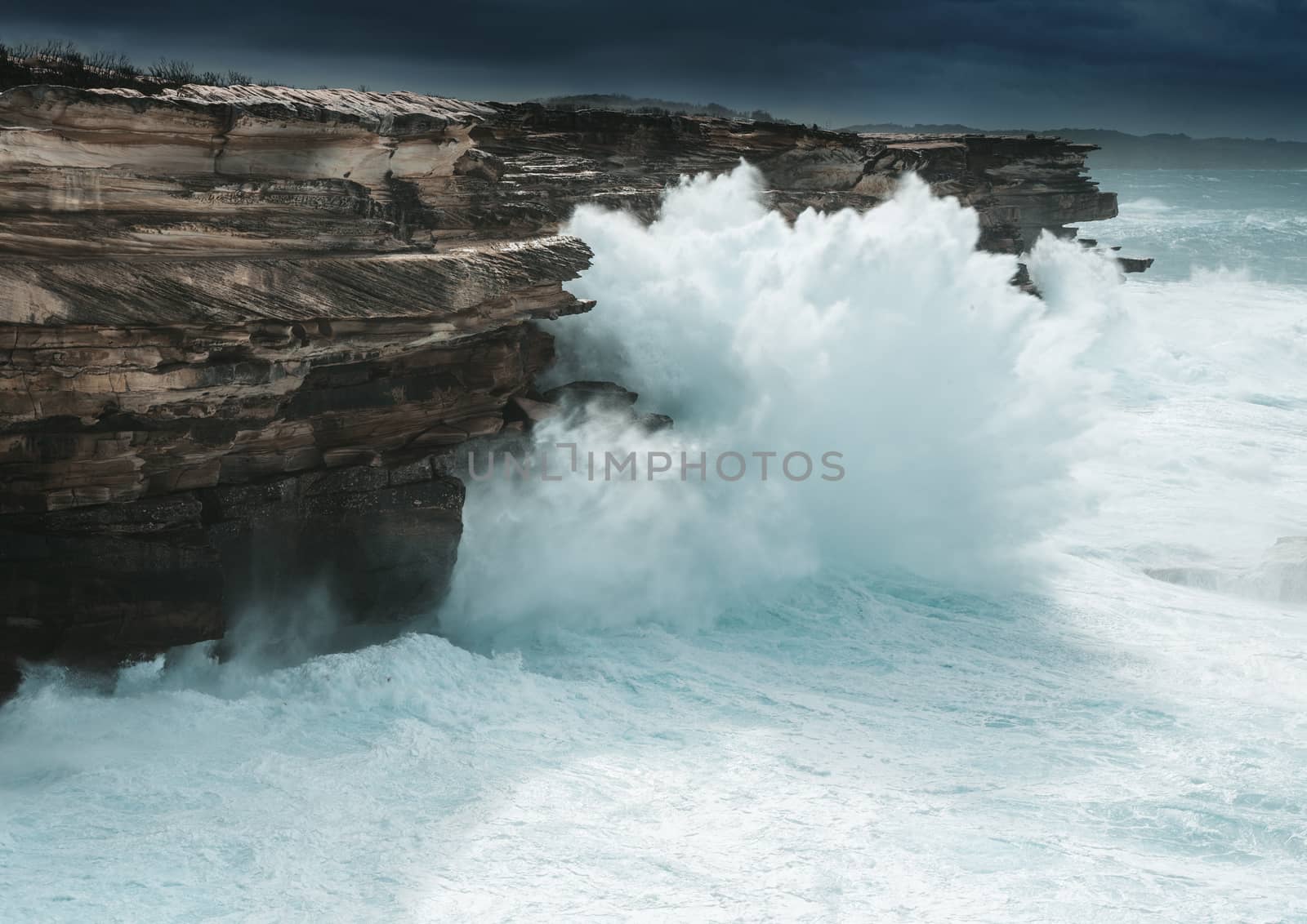 Large waves smash against the cliff coast of Sydney creating large sprays of water forced upwards to the tops of these cliffs stand around 30 metres in height