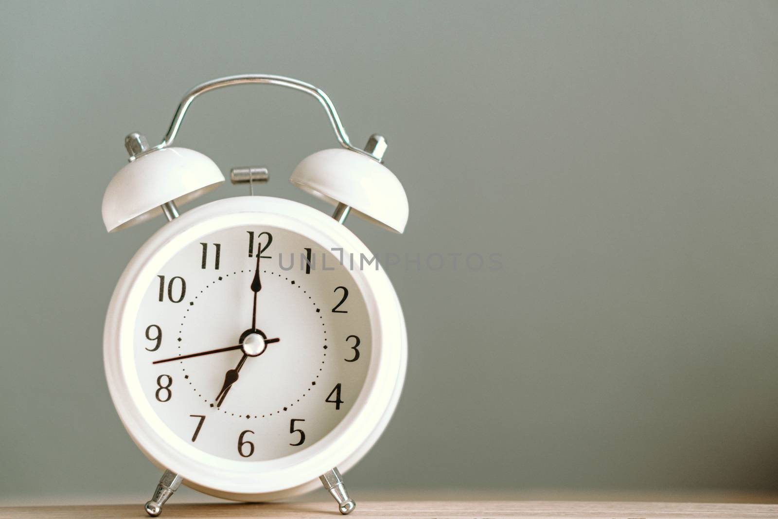 Alarm clock on white table with soft light in the morning, selective