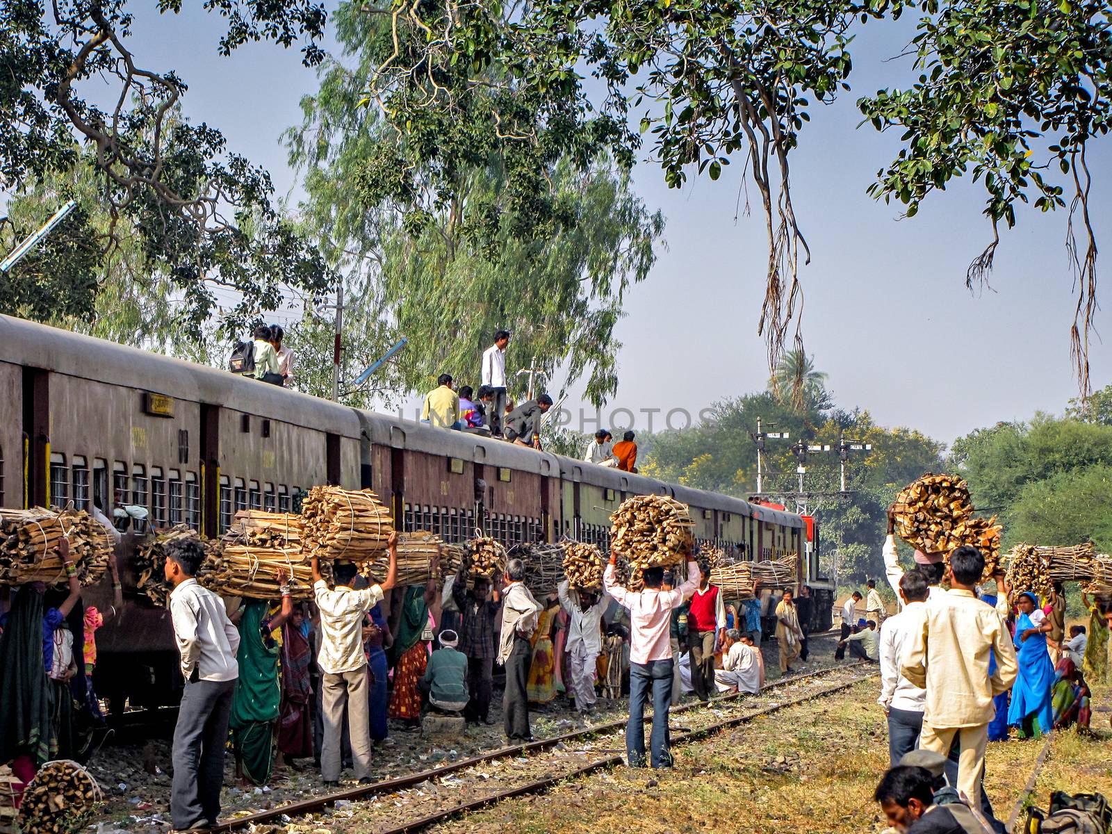 Ajanti, Madhya Pradesh, India-December 23rd, 2008:Local villagers with wood waiting for their train as pairing train waits for cro by lalam
