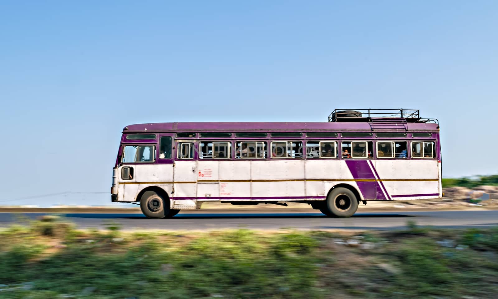 Isolated , slow shutter speed panning image of a speeding state transport bus on highway in Maharashtra, India.
