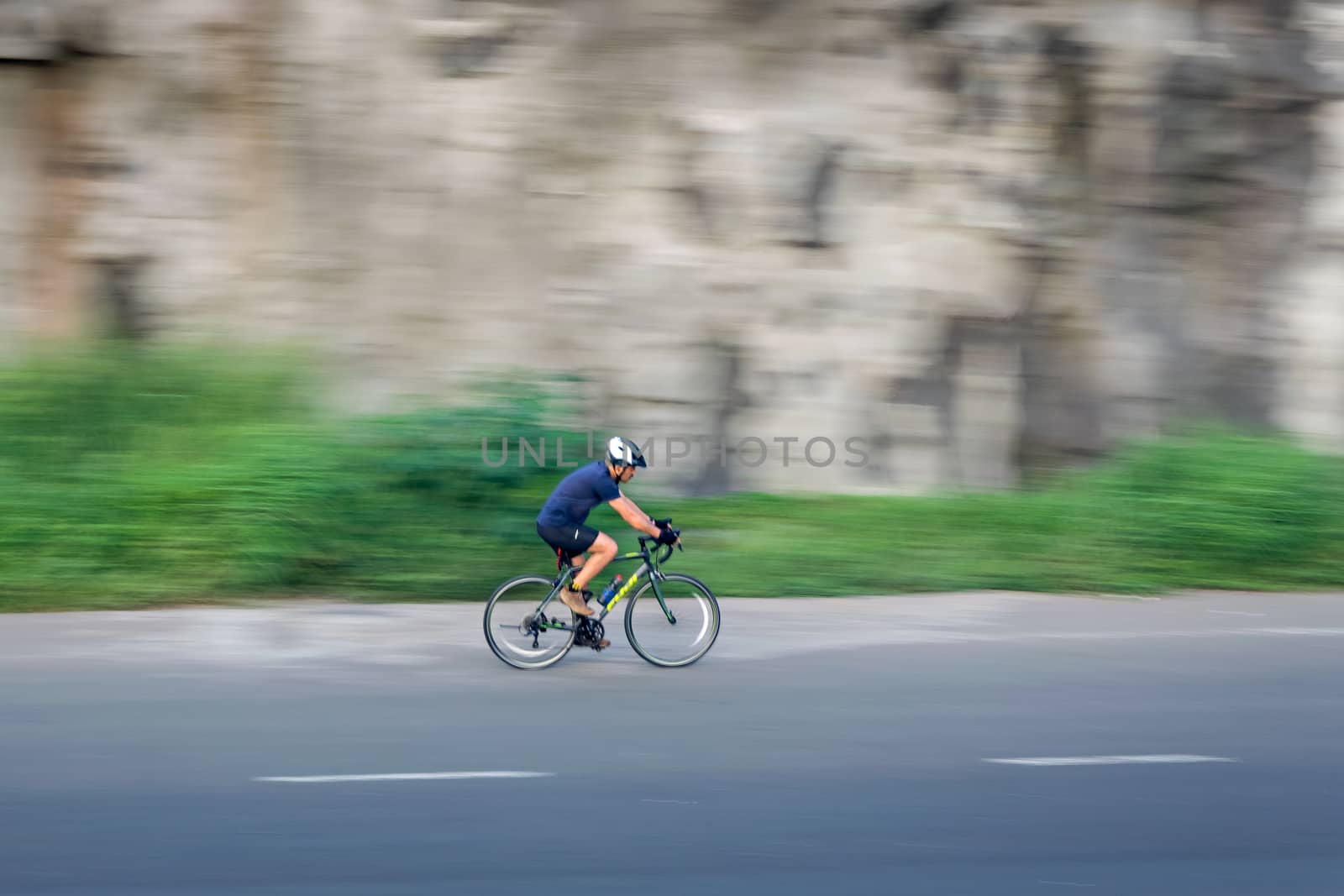 Pune, Maharashtra, India - October 4th, 2017 : Motion blur, panning image of a bicycle rider wearing helmet for safety on a way fo