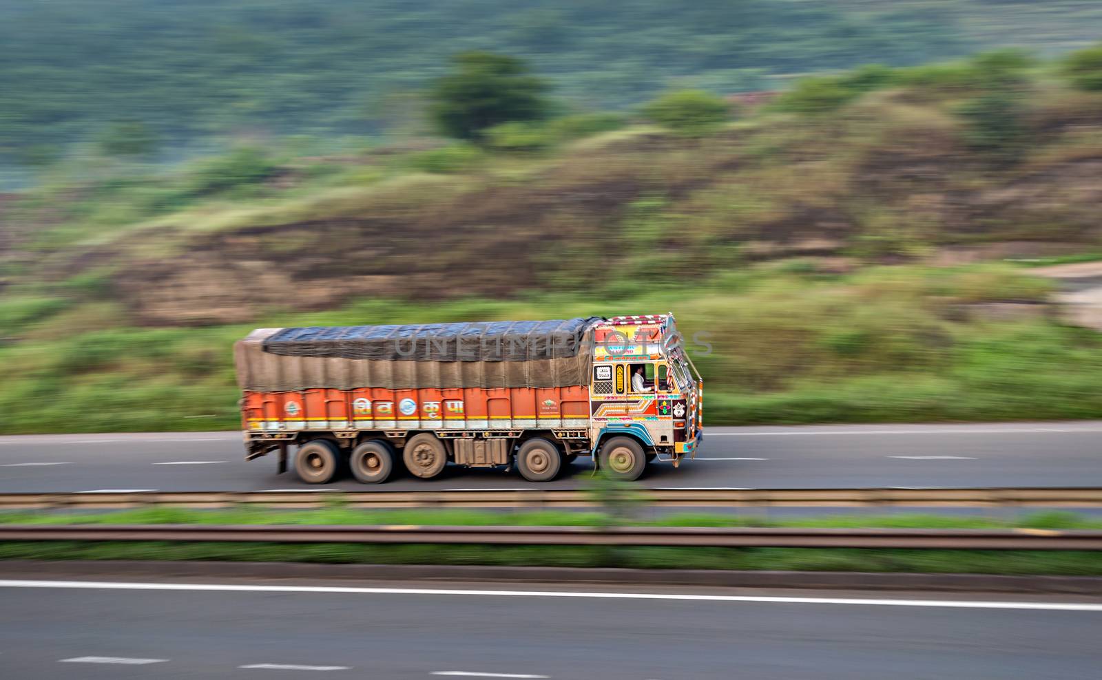 Motion blur image of a goods truck speeding on a highway in Pune, Maharashtra, India. by lalam