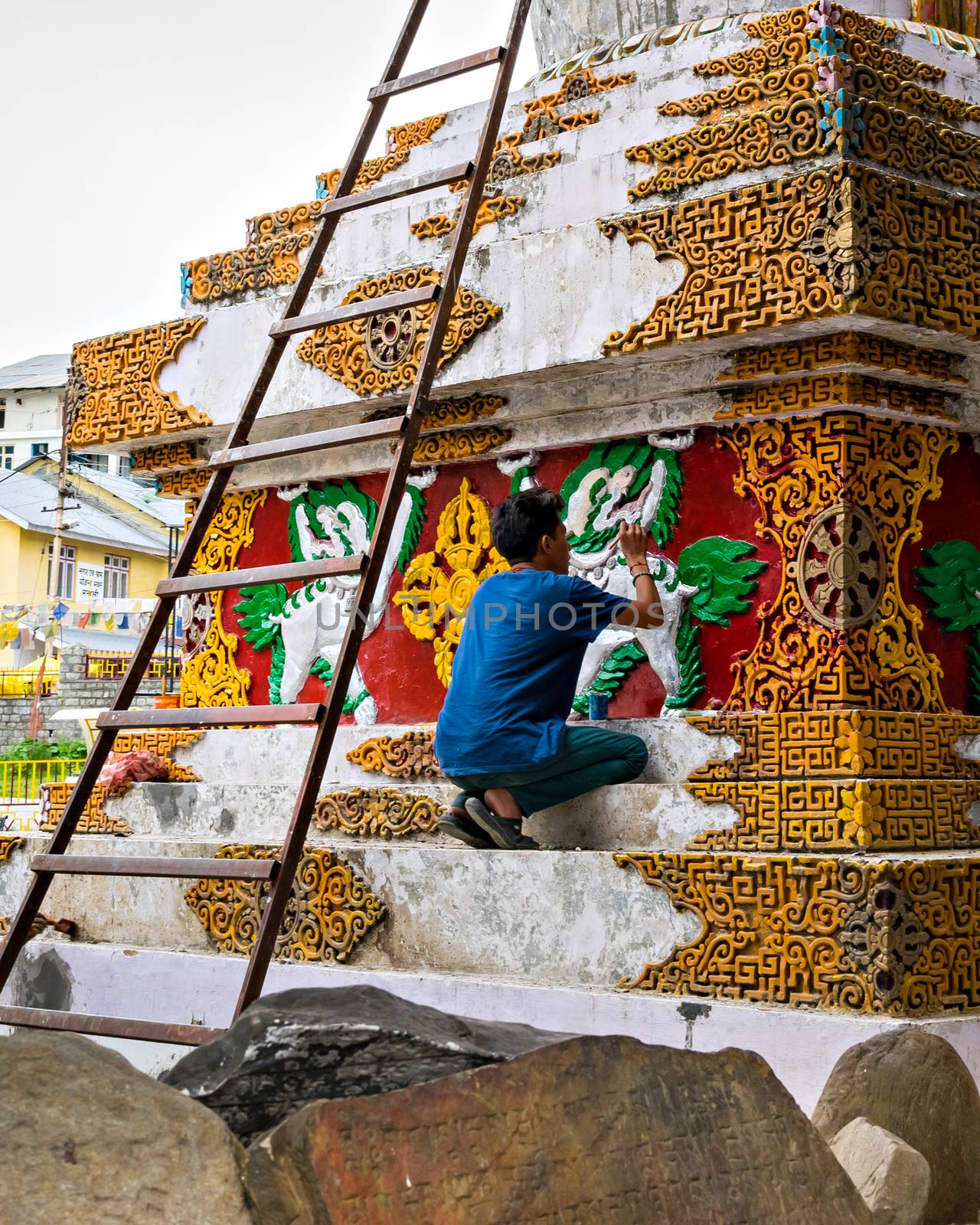 Artist painting with bright colours pagoda in Manali, Himachal Pradesh, India. by lalam