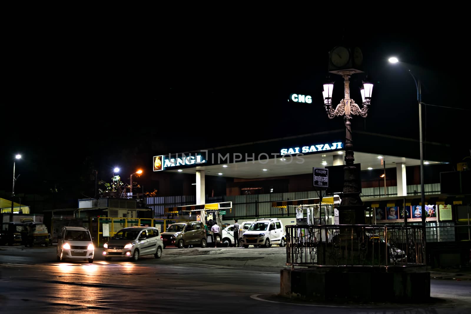 Pune, Maharashtra, India - December 5th, 2018: Compressed Natural Gas filling station serving vehicles at night.