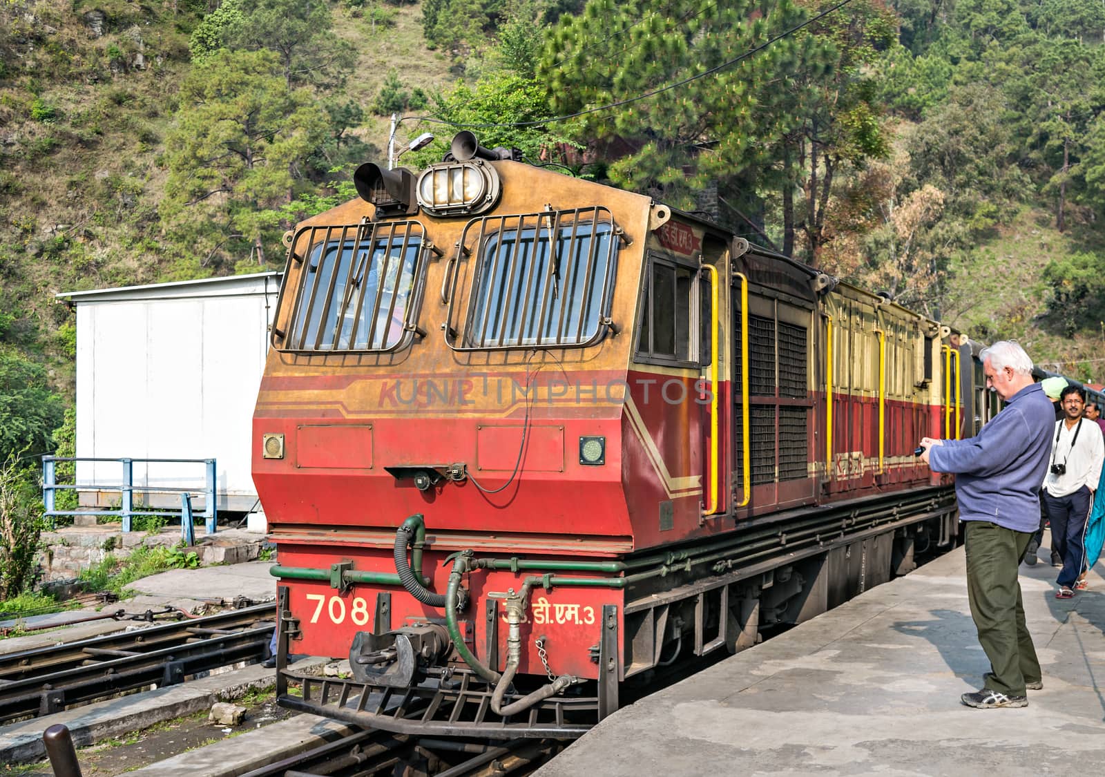 Kalka to Shimla Shivalik Deluxe express halts at Barog as curious tourist take a photograph of locomotive.