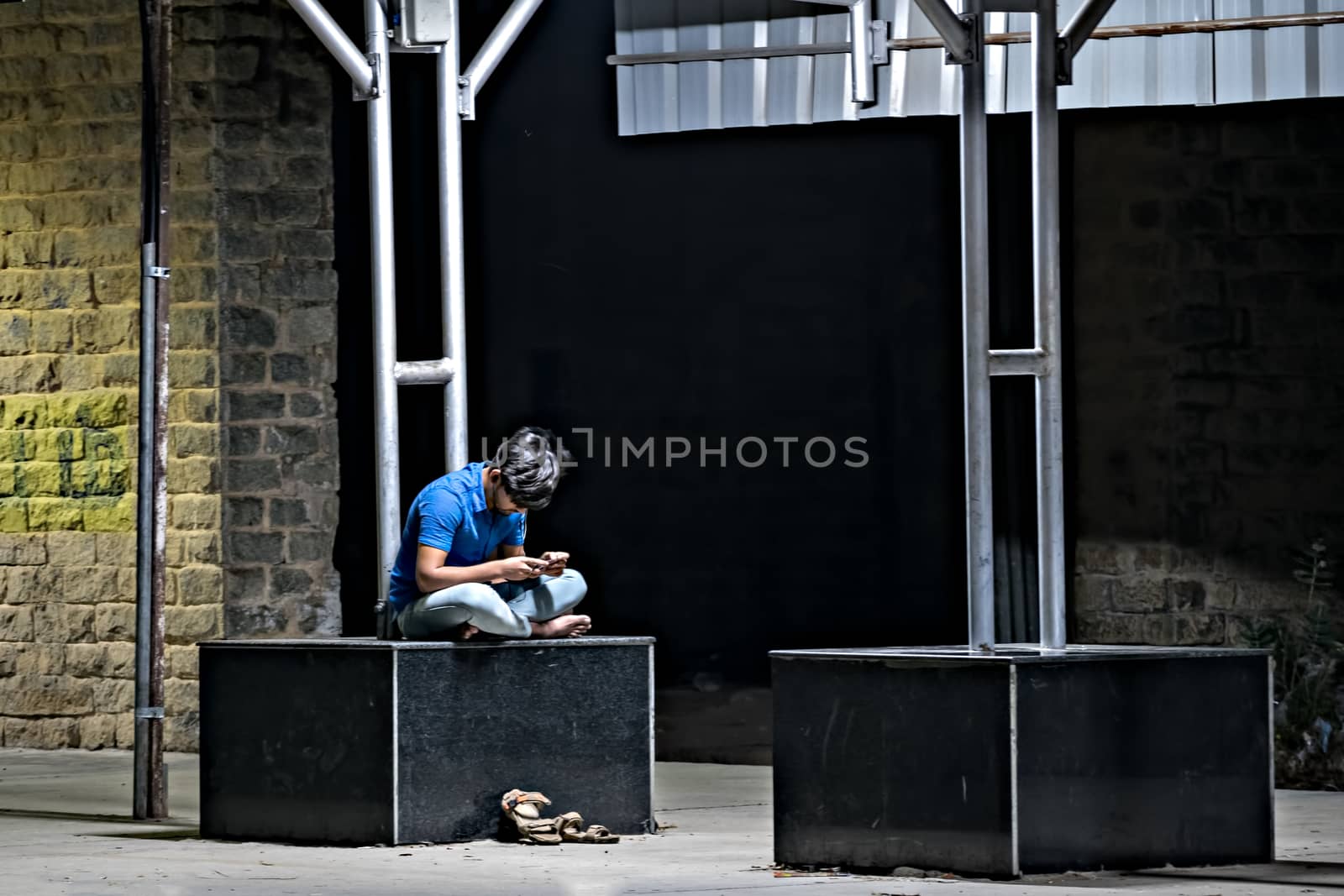 Udupi, Karnataka, India:January 30th, 2019 - Youth engrossed in his cell phone on railway platform. by lalam