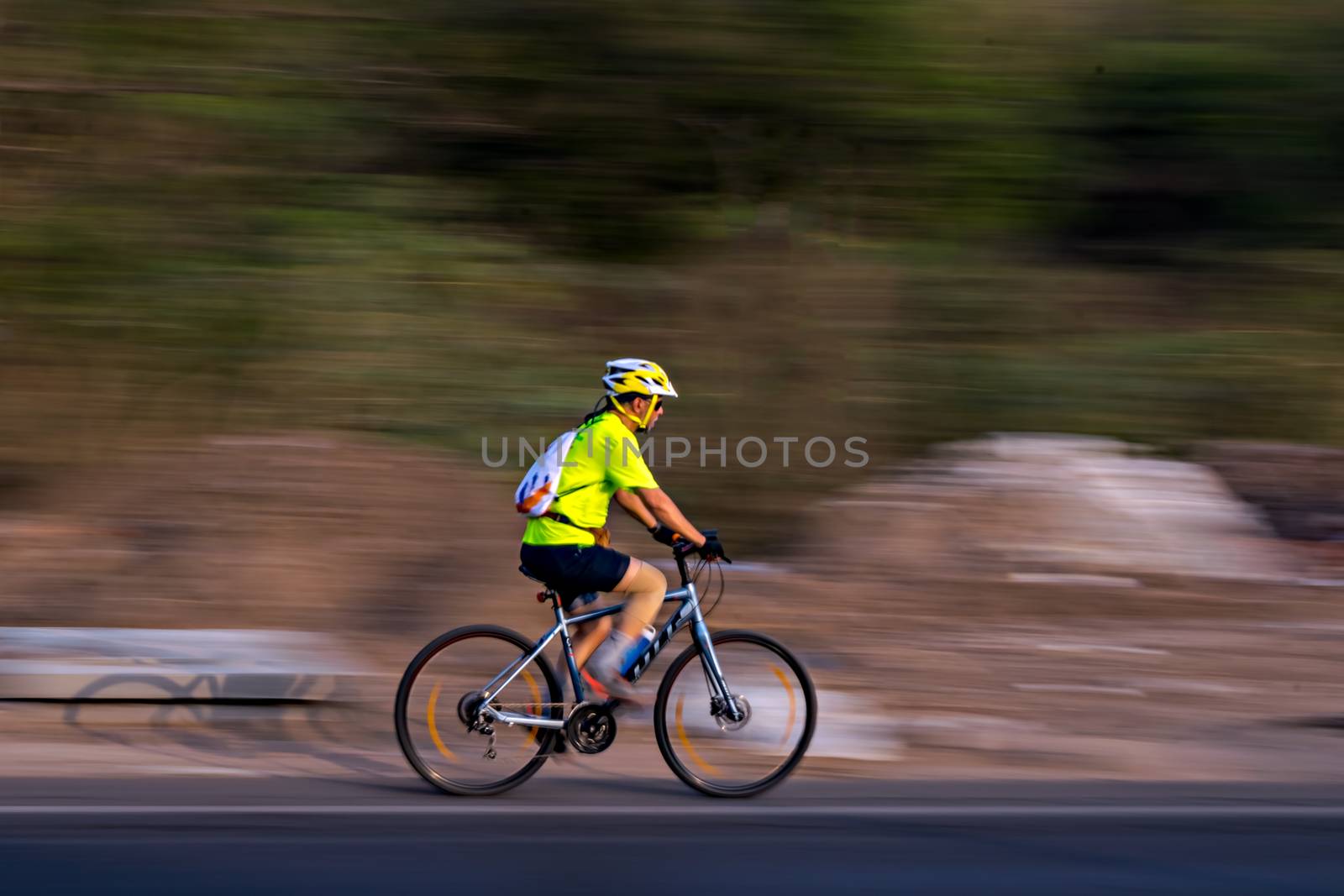 Pune, Maharashtra, India - October 4th, 2017 : Motion blur, panning image of a bicycle rider wearing helmet for safety. by lalam