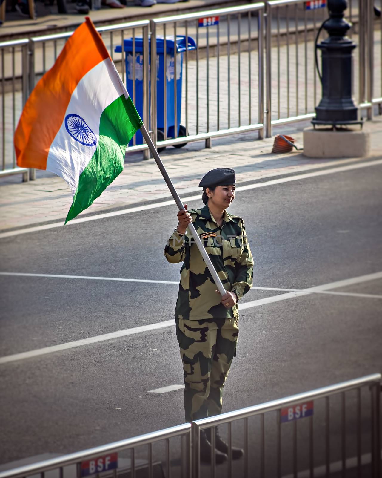 Wagah border, Punjab,  India - April 14th, 2019 : A lady officer of Indian Border Security Force, waving Indian National Flag during evening military drill jointly done by Indian & Pakistani forces.
