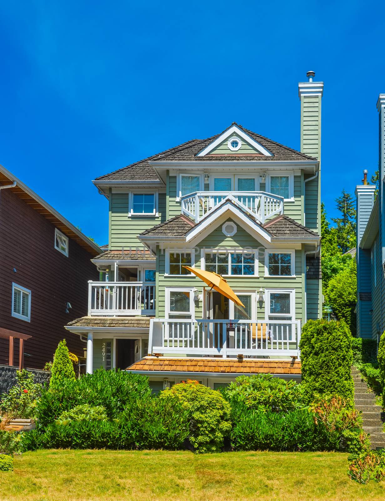 Residential house on summer day with landscaping in front