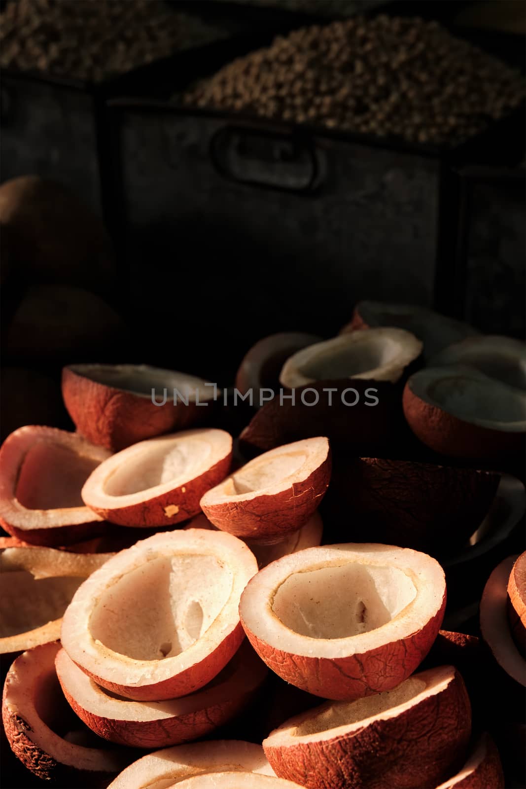 Coconuts in vegetable market in street lit by sun in India by dimol