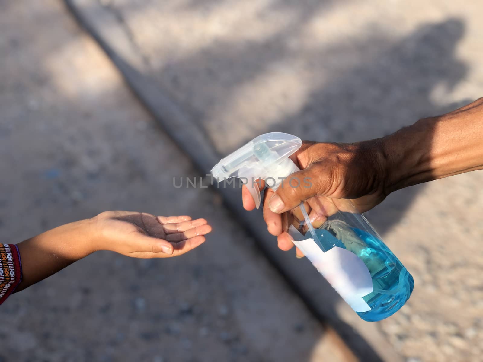 Public health officials inject alcohol spray into the hands of students to kill and prevent the spread of the covid-19 virus. In front of the school.