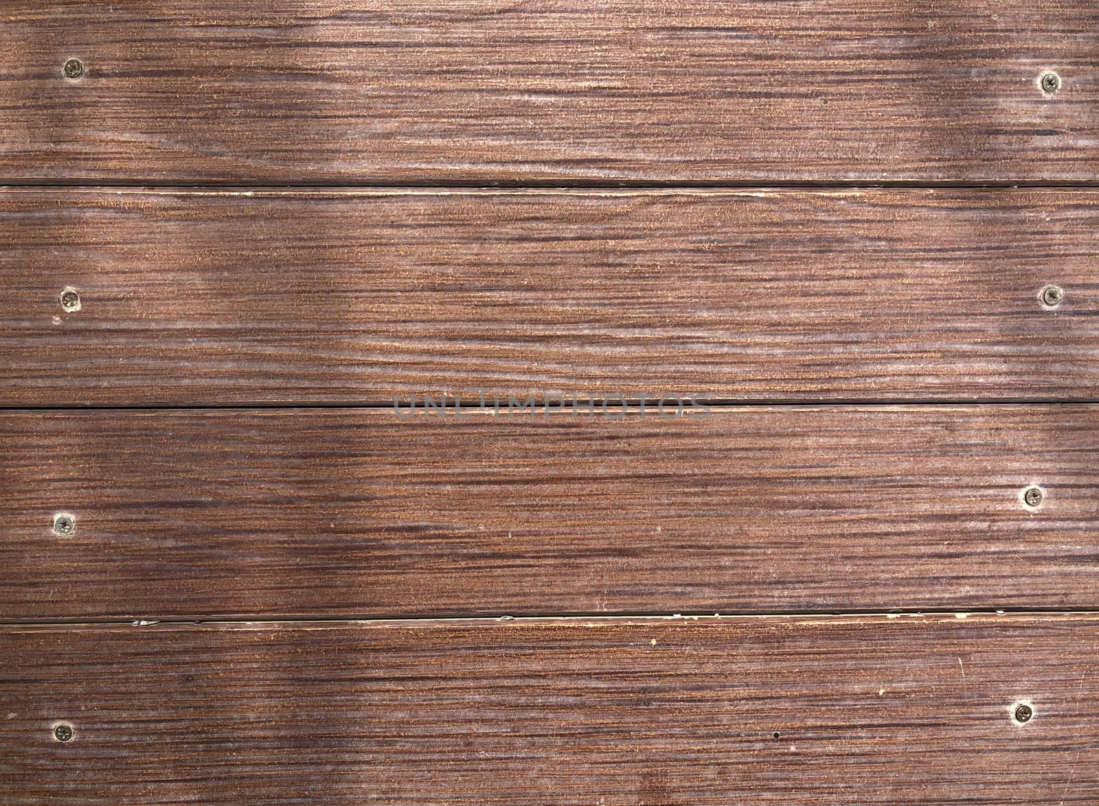Abstract brown wooden surface with screws attached to the background, brown wood texture.