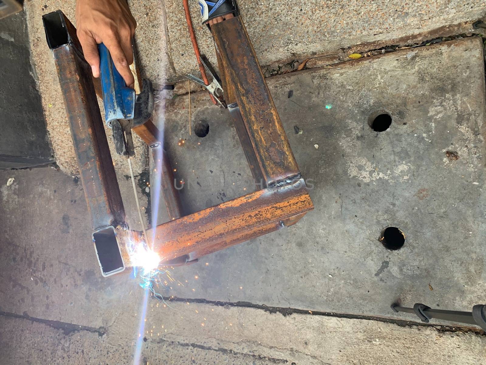 The welders are welding the gas to repair in the factory without protective gloves.