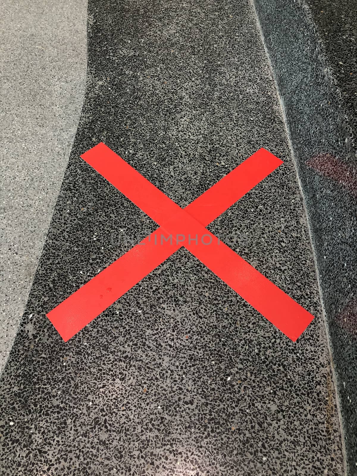 The red cross on the surface of the marble shows a symbol forbidding sitting. To keep social distance to prevent the spread of the COVID-19 virus in Thailand.
