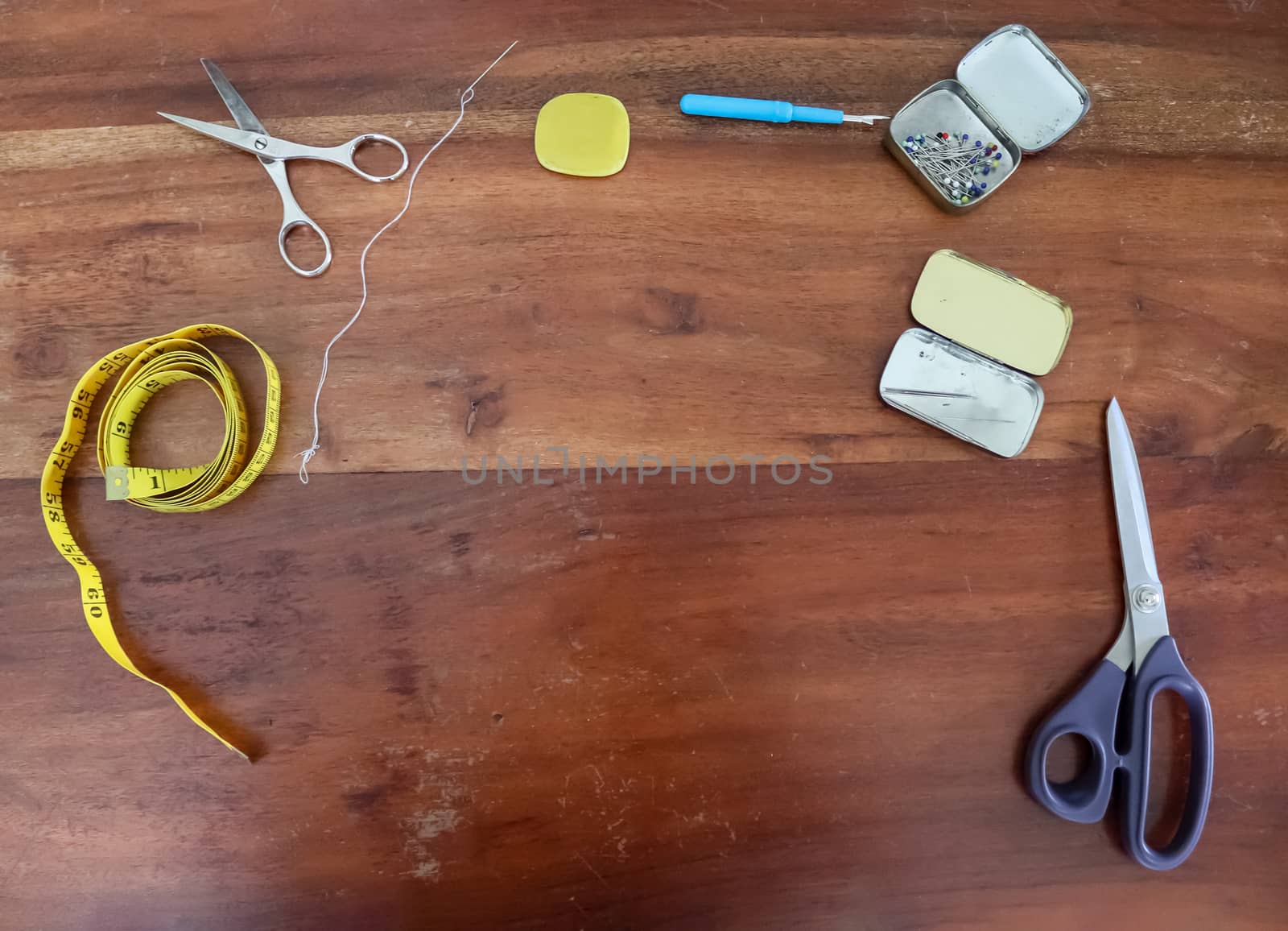 Different sewing accessoires on a brown wooden background. Sewing concept.