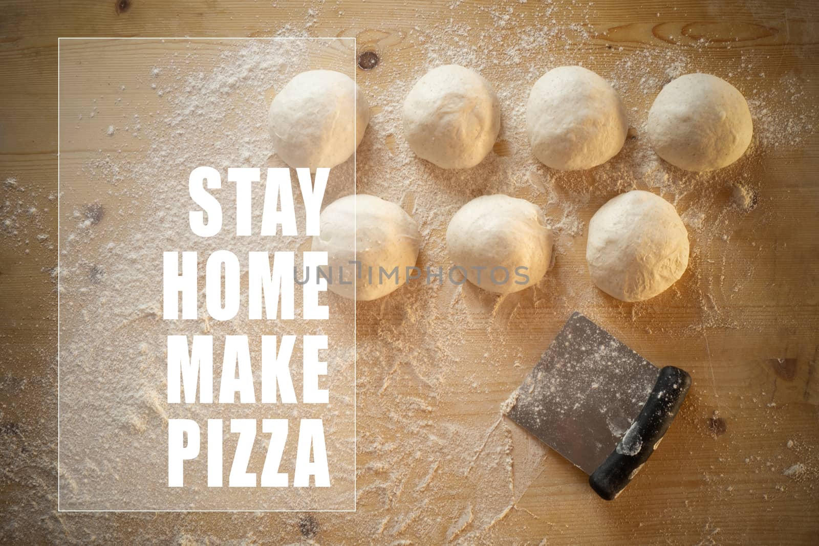 Stay at home for coronavirus covid-19 lockdown concept: white text stay home make pizza in frame on top view of leavened dough portions ready to bake on a light wooden table dusted with flour