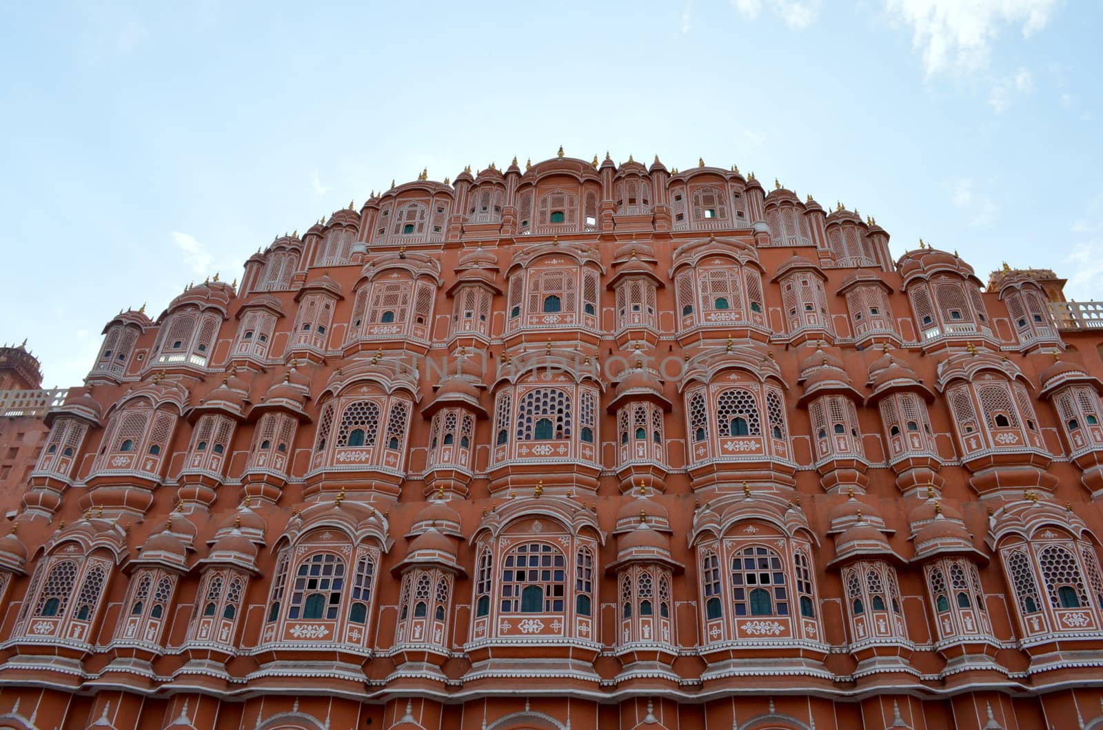 Low angle shot of Hawa Mahal from across the street. Hawa Mahal is constructed of red and pink sandstone. The structure was built in 1799 by Maharaja Sawai Pratap Singh in Jaipur, Rajasthan, India.